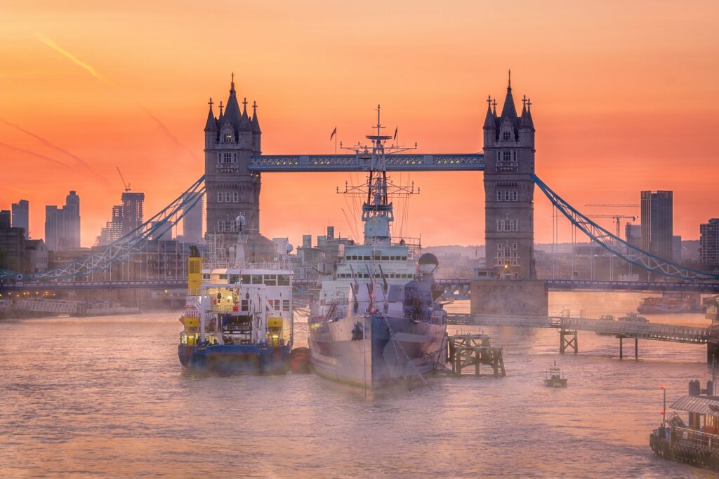 Tower Bridge at sunrise with a ship on the Thames, representing UK international trade and exporting from the UK